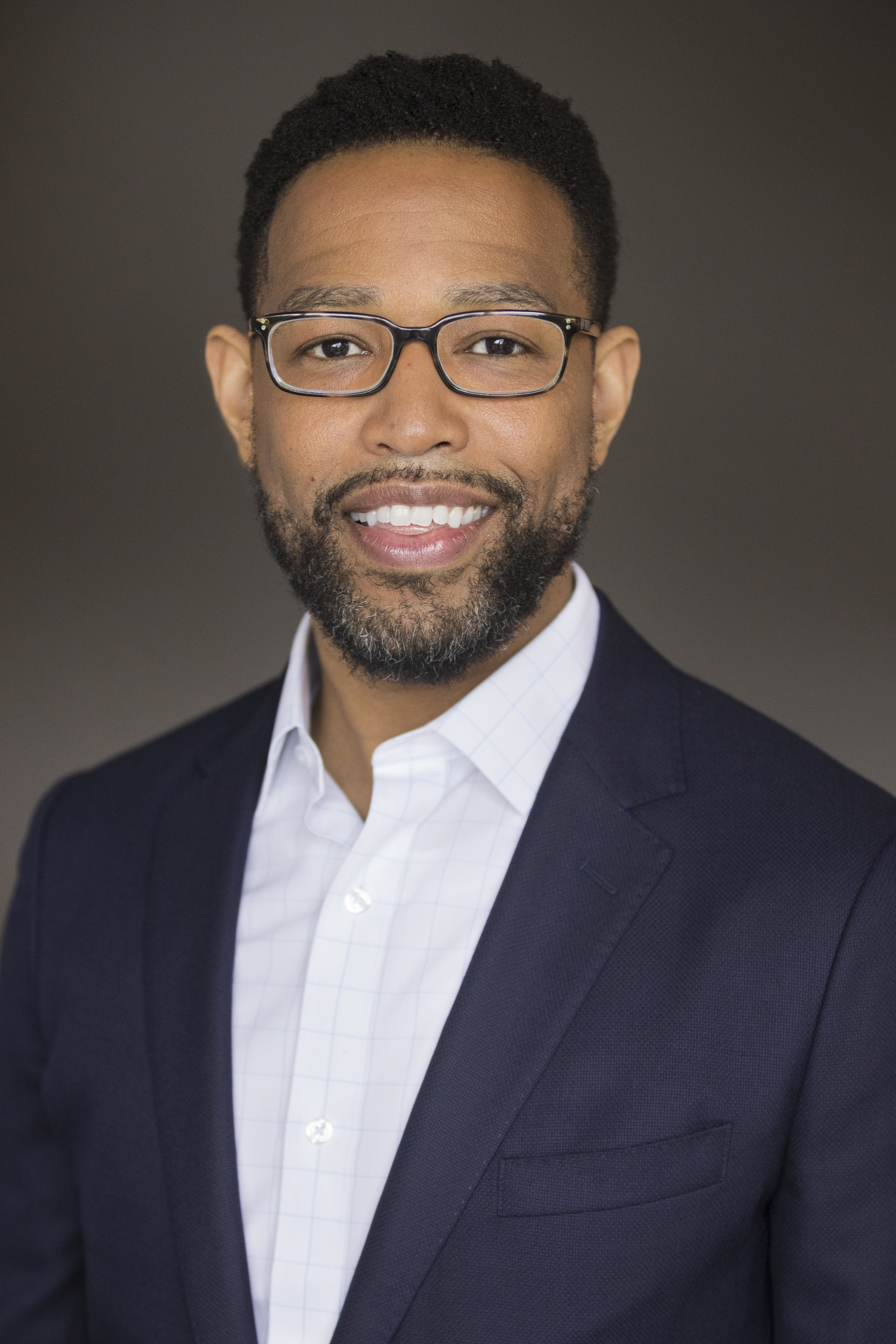 Picture of a man in a suit wearing glasses