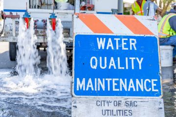 Water Quality Maintenance sign in front of truck gushing water