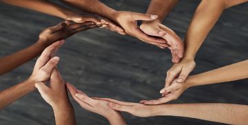 Hands in a circle with varying shades of skin tone