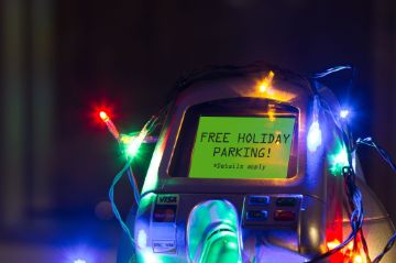 Top of a parking meter strung with Christmas lights