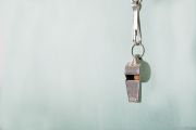 Whistle hanging in front of a light blue background