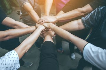 Hands in center on top of another to show teamwork