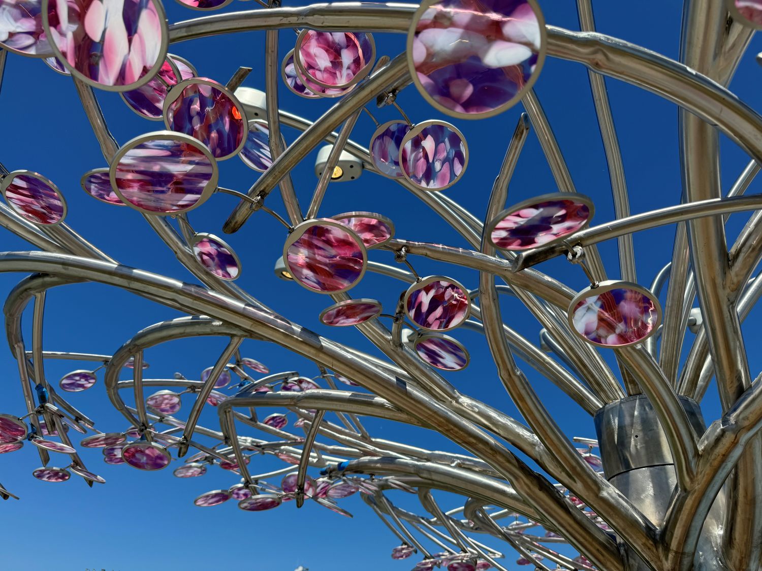 A sculpture is silouetted against the MOSAC building - an historic powerplant with a large domed roof.