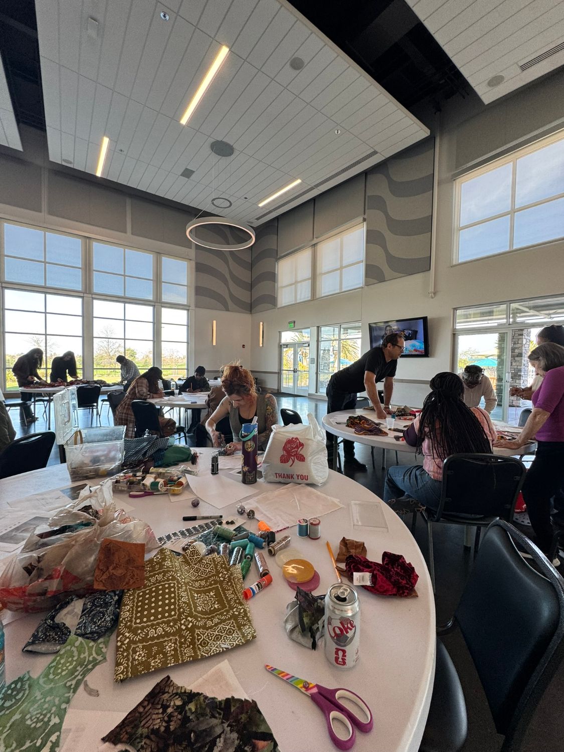 A room full of people who mingle in groups of 2, 3, or four. People are talking and visiting.