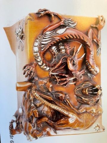 Image of a decorative box made of bronze. There are a dragon and a tiger that twist around each other as if posturing for combat. The figures form a rough ying-yang shape. The decorative elements continue down the sides of the box. 