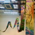 A colorfully painted cloth hangs from the ceiling like a kite 