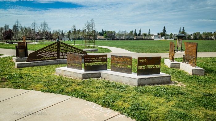 Sculptures with words carved out, sitting in the middle of a park