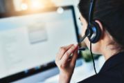 customer service agent with headset on looking at a computer