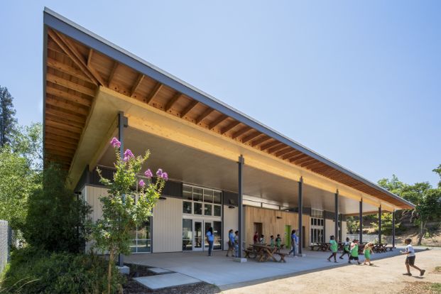 Photo of Floyd Farm at the Food Literacy Center, a large paved area under an awning, children and staff can be seen playing and working