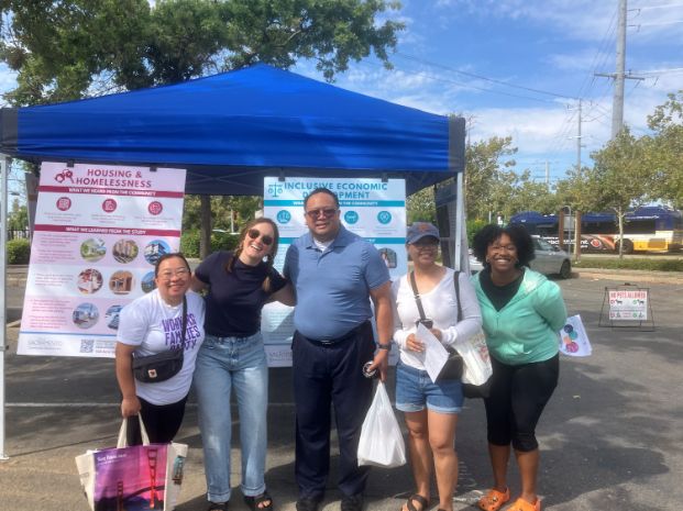 Five people pose for a group photo with their farmer's market finds.