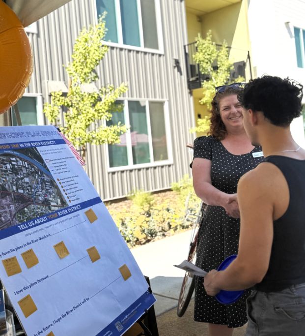 Taken during a community event, City staff talk to community members about the River District Specific Plan