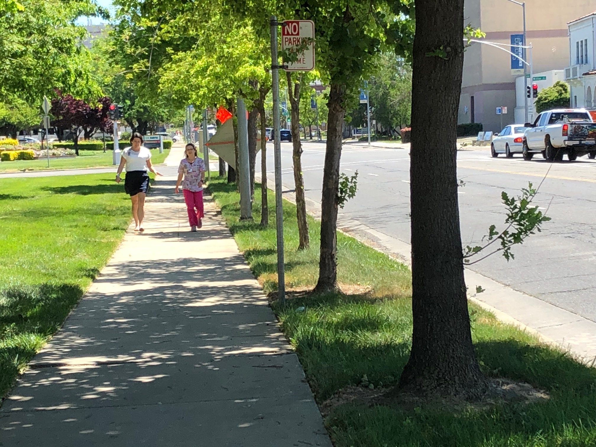 two people walking on a sidewalk near stockton blvd in sacramento