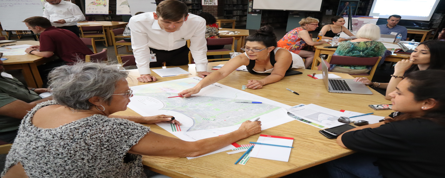 group of people working on a map at a round table