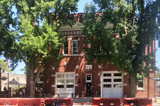 1215 19th street, a brick building framed by trees in the street. 