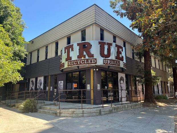 1900 K Street, a corner building with curved signage that says "TRUE, recycled, urban". 