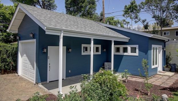 photo of a small blue house with white trim.