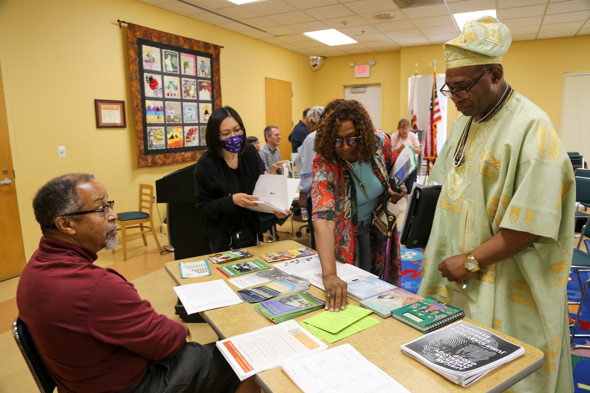 A diverse group of residents look over documents together. 