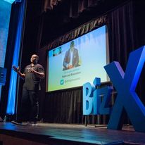 Image of a speaker on stage at Biz X event.
