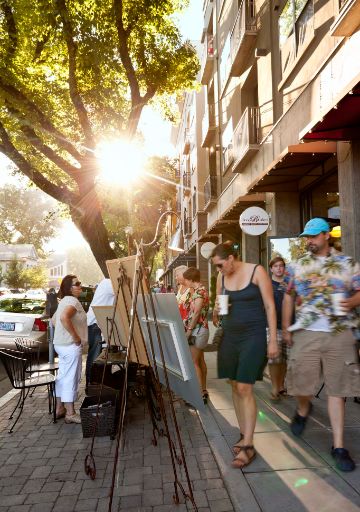 An image of an art show on city sidewalk