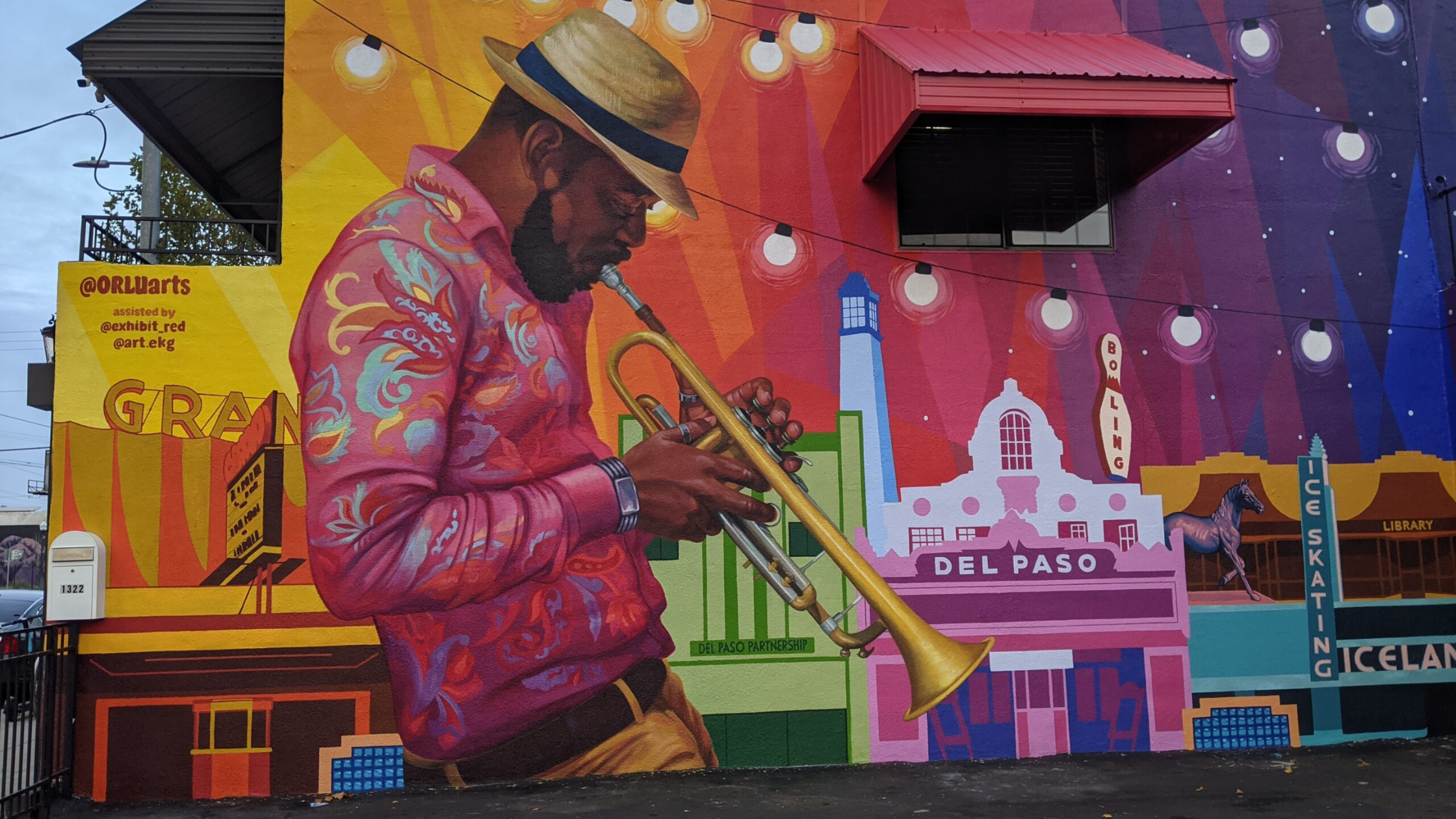 Image of mural in Del Paso Heights of man playing a saxophone on colorful backdrop. 