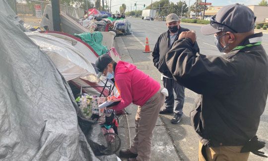 Workers assisting unhoused resident