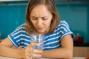 Woman looking into glass of water