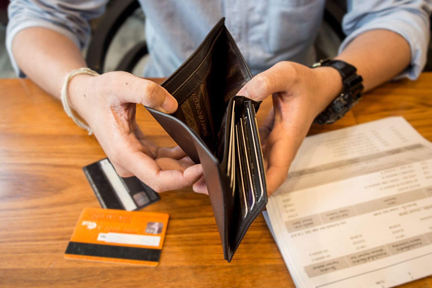 Hands holding a wallet with no cash