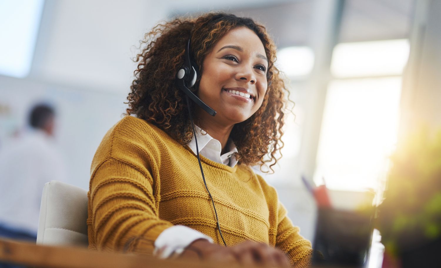 African American woman wearing a headset working on a computer