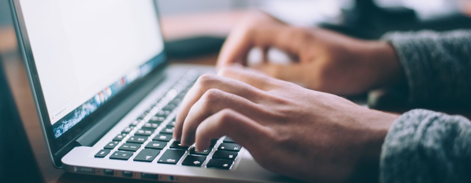 Hands typing on a laptop.