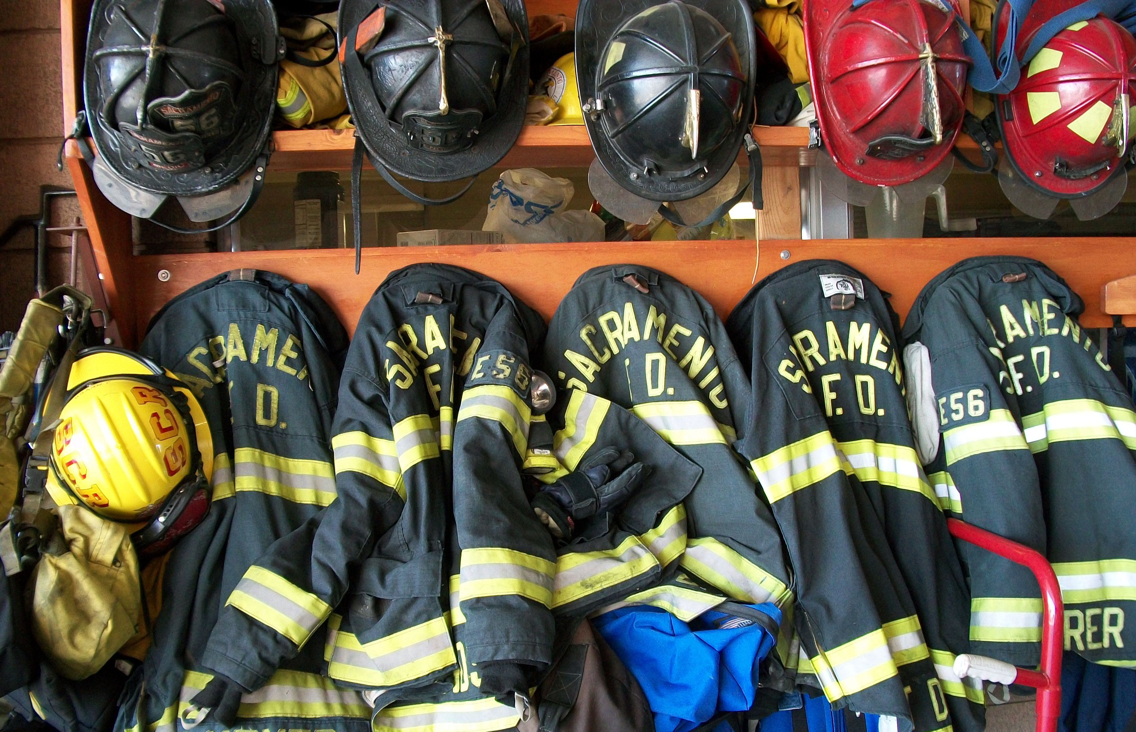 Black firefighter jackets and helmets hanging
