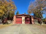 Fire station 11 front building with red garage doors and trees in front 