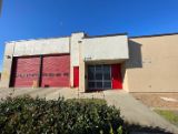 Station building beige with 2 red garage doors and front glass door