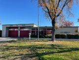 Fire Station 16 front of the building with red garage doors and flag pole 