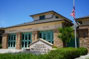 Station 30 front of the building with a sign and flag pole green glass doors 