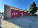 Station 56 front of the building with 4 red garage doors and a tree 