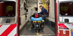 Firefighter sitting in the back of the ambulance checking out equipment