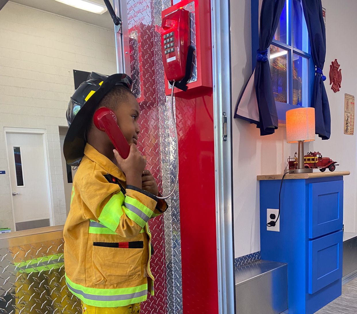 KID ON A PLAY PHONE IN FULL FIRE GEAR