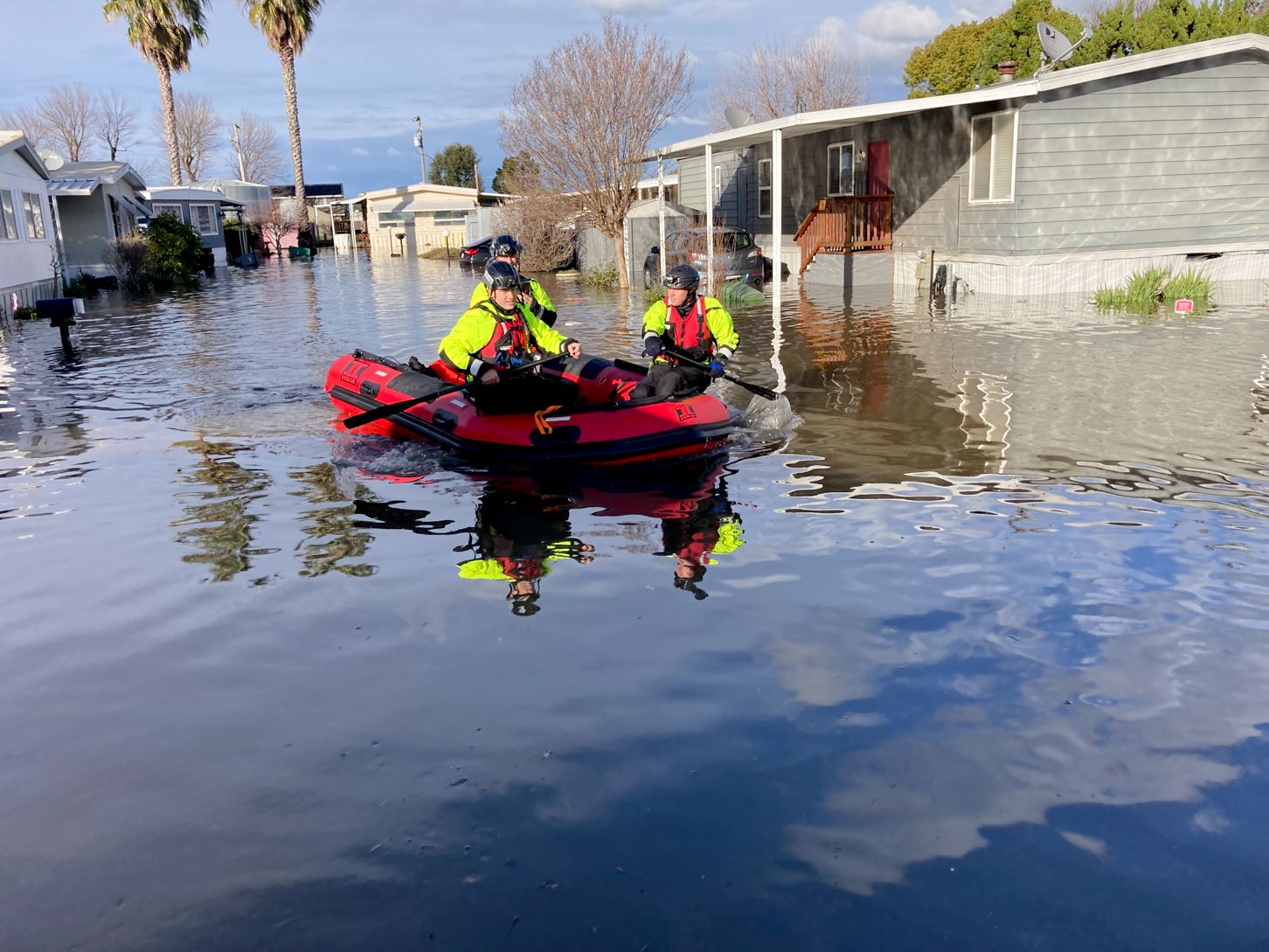 people in inflatable boat on a flooded street