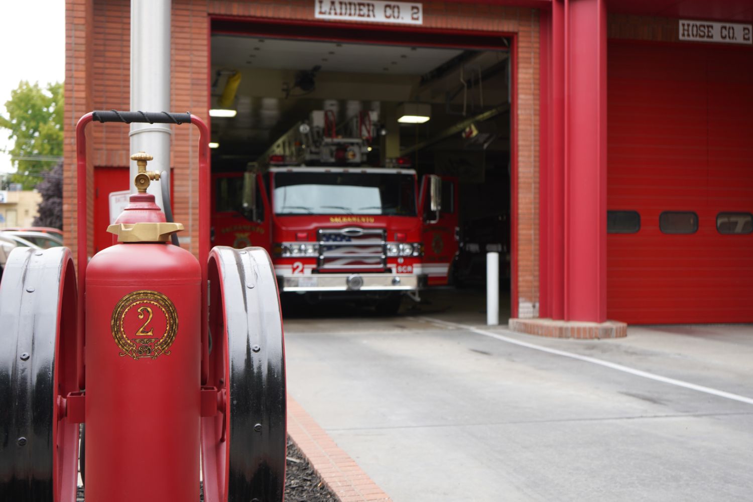 vintage fire extinguisher in the background a fire truck coming out of a garage door