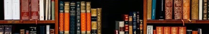 book case filled with many neatly shelved hardcover books in varying colors.