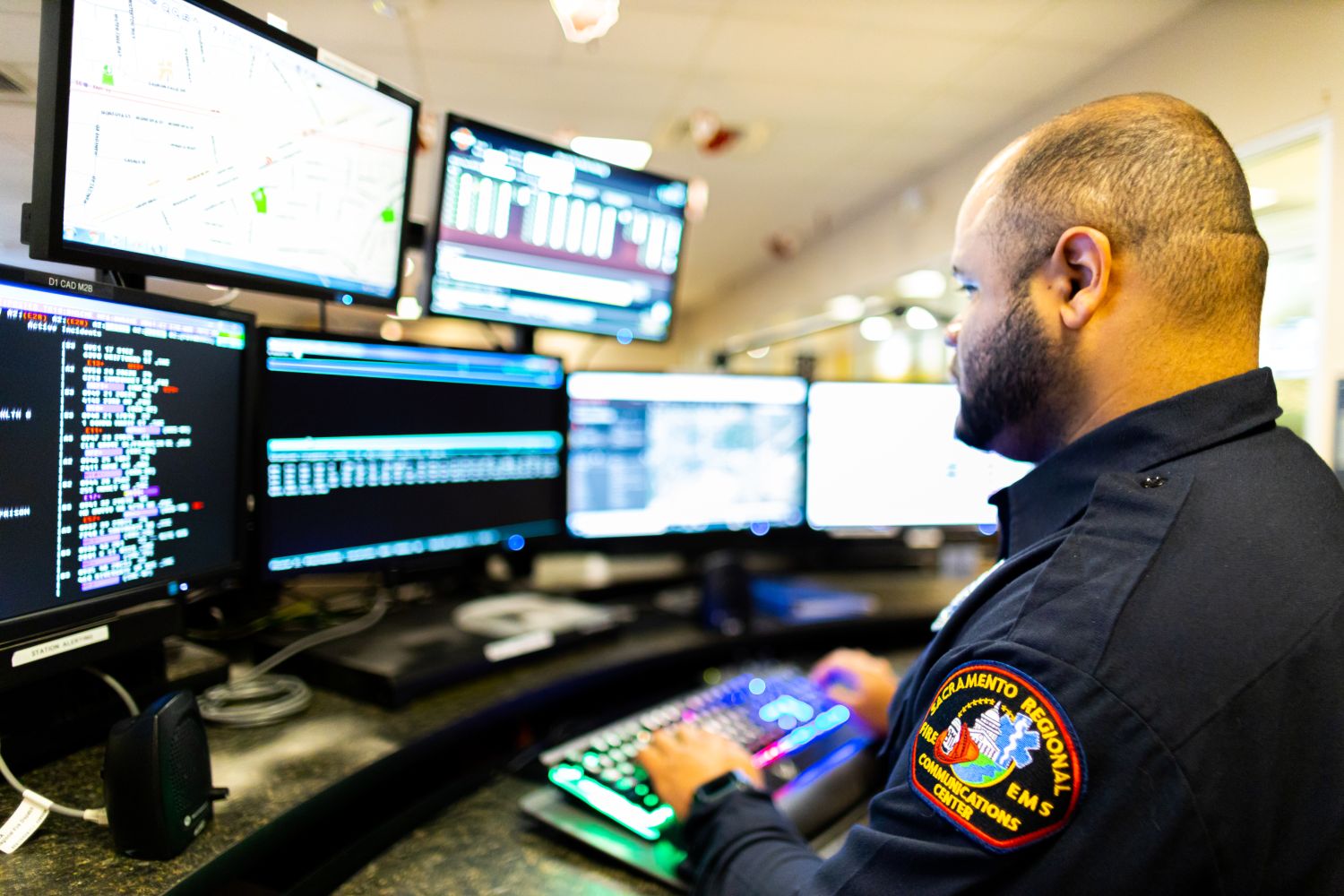 a 911 phone operator sitting in front of computer monitors.