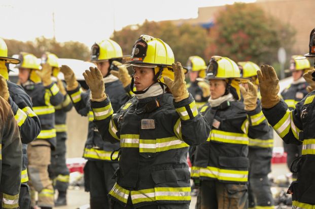 Fire recruits holding hands up during a PPE drill 