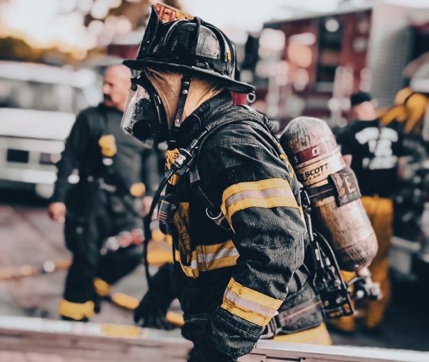 Firefighter in turnouts walking and profile view