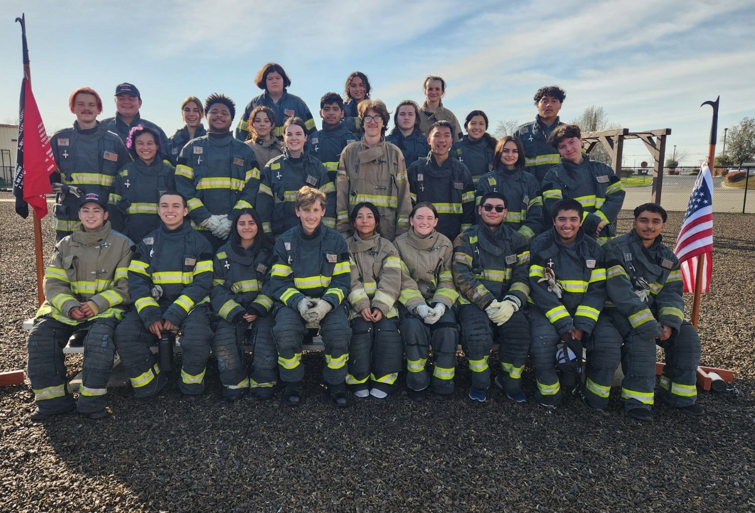 Fire cadets sitting on bleachers in full turnouts