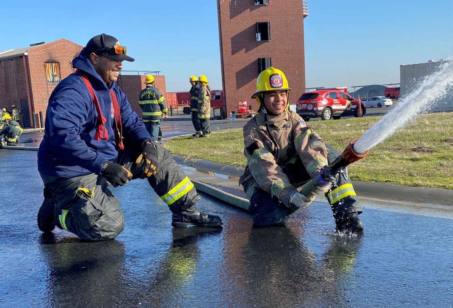 cadet in turnouts kneeling practing nozzle control