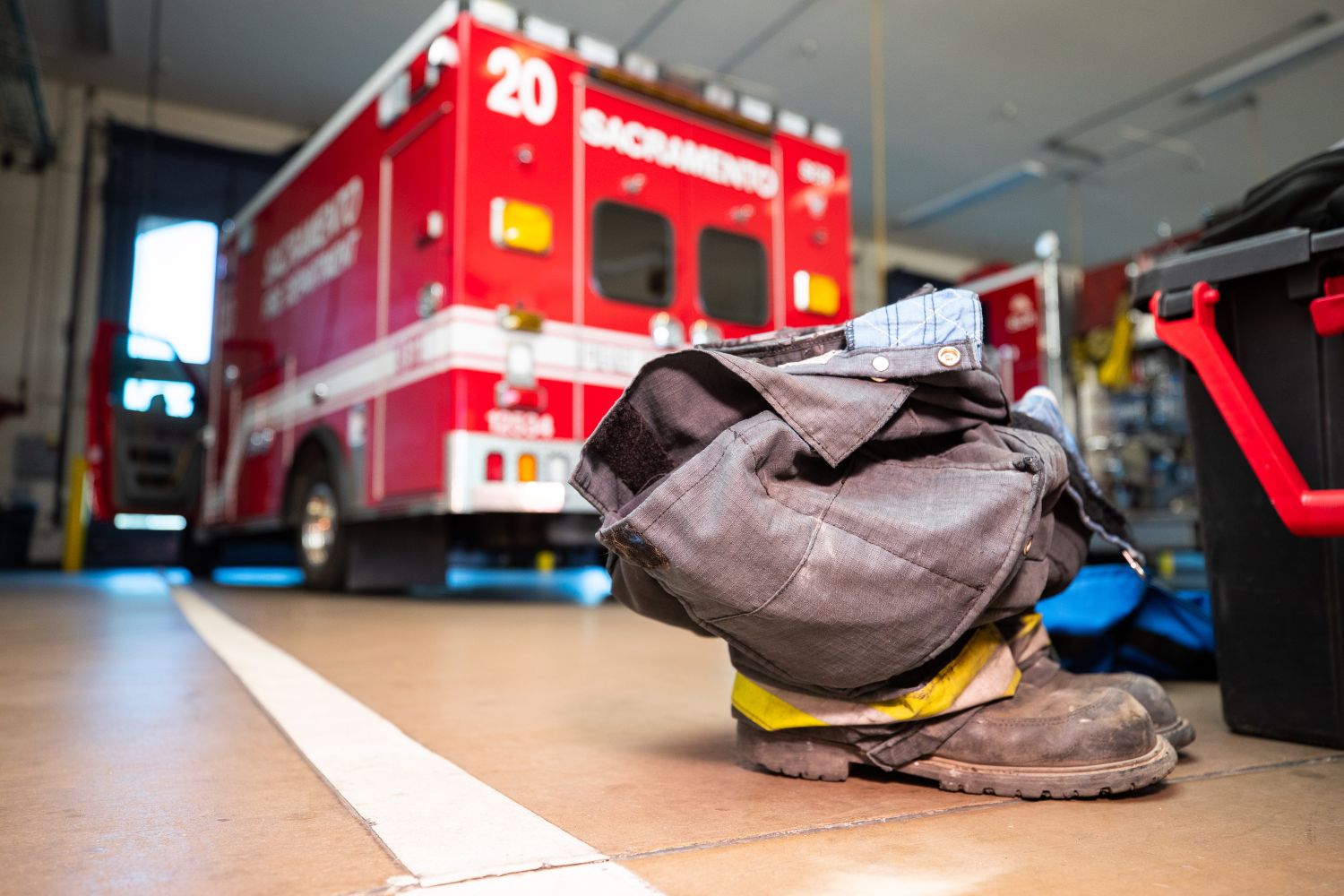 a pair of boots on the floor with an ambulance in the background.