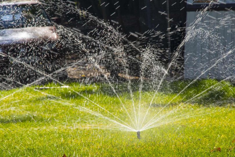 A sprinkler spraying water in grass
