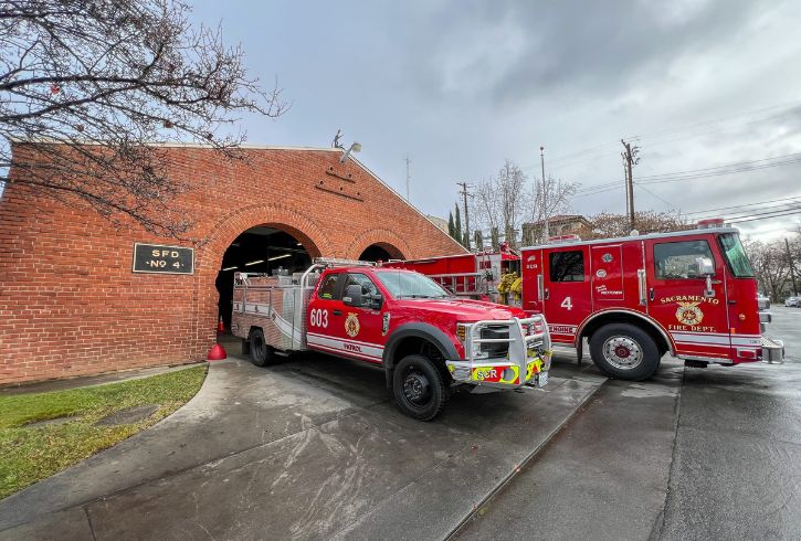 Two fire frucks, red brick fire station
