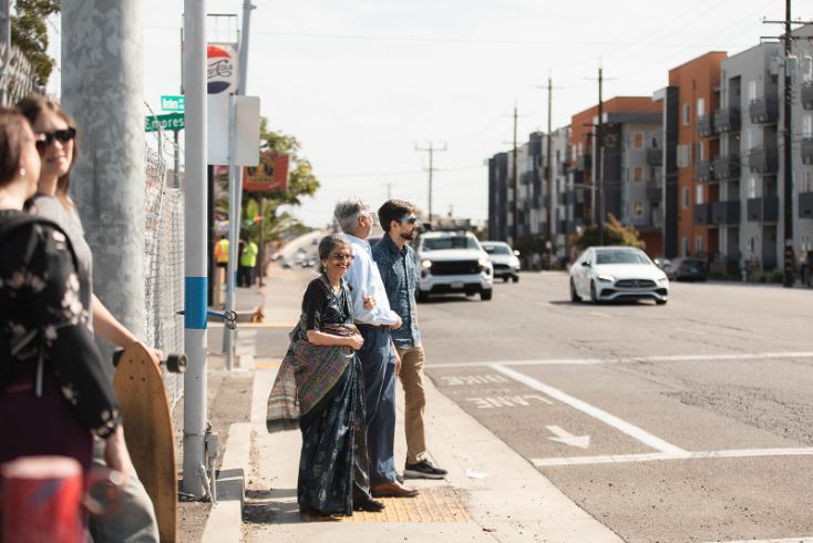 People crossing the street, cars, buildings