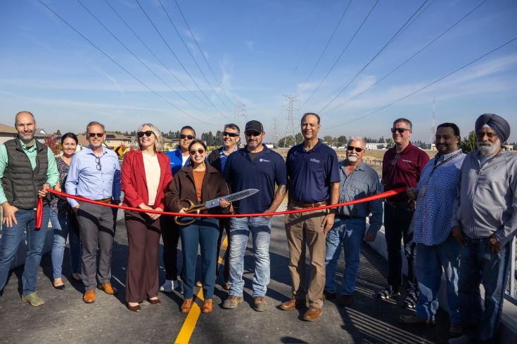 Group photo at ribbon cutting, large red ribbon